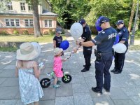 Zdjęcie przedstawiające policjantów oraz dzieci w parku.