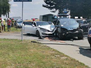 Zdjęcie kolorowe, przedstawiające miejsce zdarzenia drogowego oraz uszkodzone pojazdy.