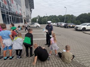 Zdjęcie przedstawiające policjanta oraz dzieci biorące udział w spotkaniu.