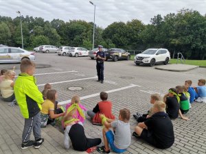 Zdjęcie przedstawiające policjanta oraz dzieci biorące udział w spotkaniu.