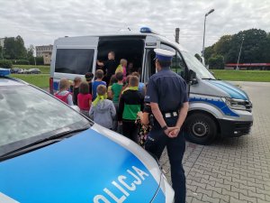 Zdjęcie przedstawiające policjanta oraz dzieci biorące udział w spotkaniu.