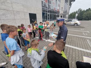 Zdjęcie przedstawiające policjanta oraz dzieci biorące udział w spotkaniu.