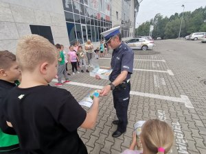 Zdjęcie przedstawiające policjanta oraz dzieci biorące udział w spotkaniu.