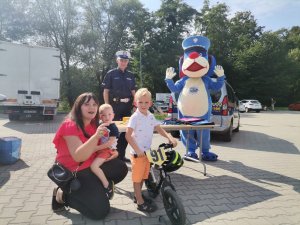 Zdjęcie przedstawiające policjanta oraz uczestników festynu.