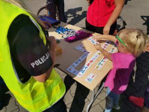 Zdjęcie przedstawiające policjanta oraz uczestników festynu.