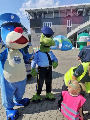 Zdjęcie przedstawiające policjantkę, Sznupka oraz uczestników festynu.