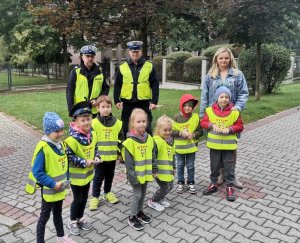 Zdjęcie przedstawiające policjanta oraz dzieci i wychowawcę.