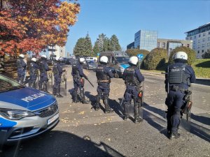 Zdjęcie kolorowe, przedstawiające policjantów w trakcie zabezpieczania przyjazdu kibiców.