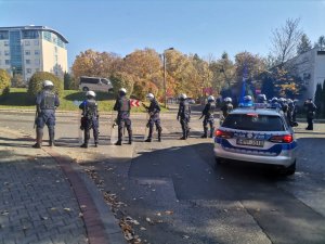 Zdjęcie kolorowe, przedstawiające policjantów w trakcie zabezpieczania przyjazdu kibiców.