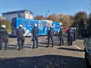 Zdjęcie kolorowe, przedstawiające policjantów w trakcie zabezpieczania przyjazdu kibiców.