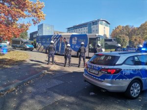 Zdjęcie kolorowe, przedstawiające policjantów w trakcie zabezpieczania przyjazdu kibiców.