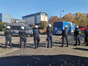 Zdjęcie kolorowe, przedstawiające policjantów w trakcie zabezpieczania przyjazdu kibiców.