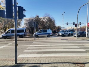 Zdjęcie kolorowe, przedstawiające zabezpieczenia przemarszu kibiców.