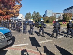 Zdjęcie kolorowe, przedstawiające policjantów w trakcie zabezpieczania przyjazdu kibiców.