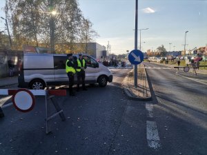 Zdjęcie przedstawiające policjanta ruchu drogowego oraz dzielnicowego pełniącego służbę w rejonie cmentarza.