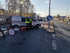 Zdjęcie przedstawiające policjanta ruchu drogowego oraz dzielnicowego pełniącego służbę w rejonie cmentarza.