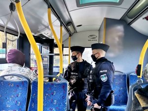 Zdjęcie kolorowe, przedstawiające policjantów w autobusie komunikacji miejskiej.