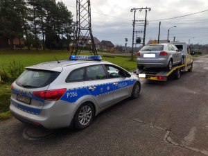 Zdjęcie przedstawiające radiowóz oraz samochód na lawecie.