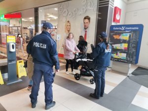 Zdjęcie przedstawiające policjantów w galerii podczas legitymowania.