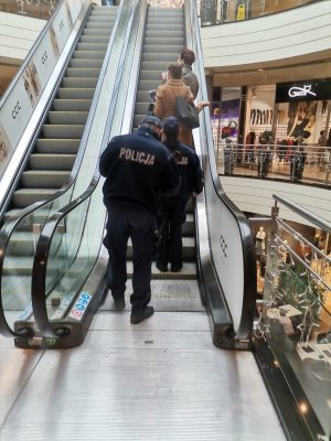 Zdjęcie przedstawiające pracowników sanepidu oraz policjantów w galerii.