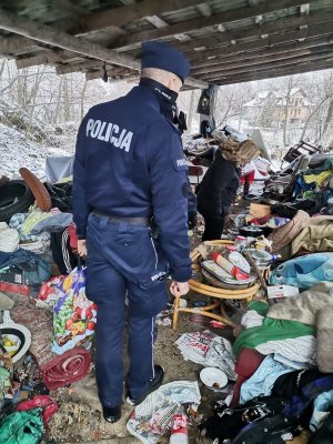 Zdjęcie przedstawiające policjanta w trakcie kontroli miejsca przebywania osoby bezdomnej.