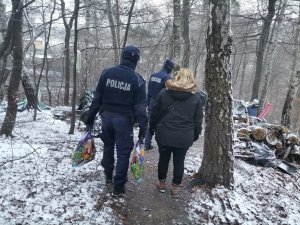 Zdjęcie przedstawiające mundurowych i pracownice OPS-u w trakcie dotarcia do miejsc przebywania osoby bezdomnej.