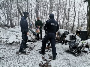 Zdjęcie przedstawiające mundurowych i pracownice OPS-u w trakcie rozmowy z osobą bezdomną.