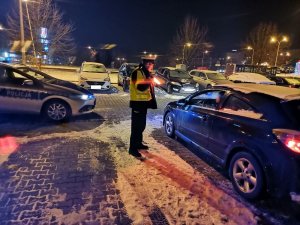 Zdjęcie przedstawiające policjanta ruchu drogowego w trakcie kontroli drogowej.