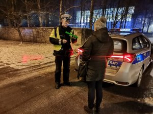 Zdjęcie przedstawiające moment wręczania przez policjanta odblasku.