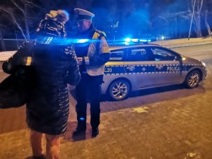 Zdjęcie przedstawiające moment wręczania przez policjanta odblasku.