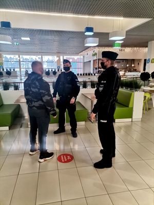 Zdjęcie policjantów w galerii w trakcie wykonywanych czynności.