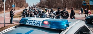 Zdjęcie przedstawiające policjanta ruchu drogo oraz radiowóz w trakcie zabezpieczenia.