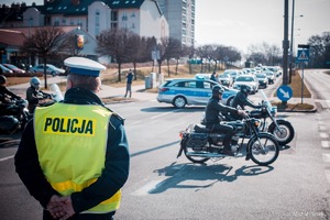 Zdjęcie przedstawiające policjanta ruchu drogowego oraz motocyklistów.