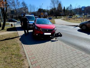 Zdjęcie przedstawiające radiowóz oraz samochód peugeot.