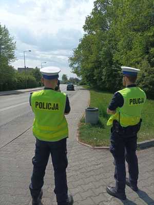 Zdjęcie przedstawiające policjantów ruchu drogowego w trakcie pomiaru prędkości.