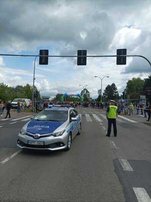 Zdjęcie przedstawiające policjanta ruchu drogowego oraz radiowóz.