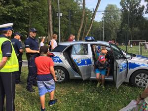 Zdjęcie przedstawiające policjanta oraz uczestników festynu.