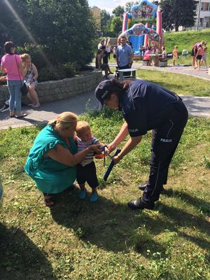 Zdjęcie przedstawiające policjanta oraz uczestników festynu.