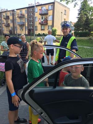 Zdjęcie przedstawiające policjanta oraz uczestników festynu.