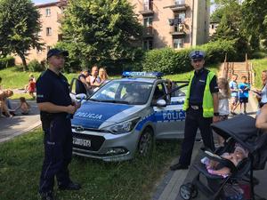 Zdjęcie przedstawiające policjanta oraz uczestników festynu.