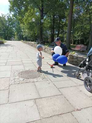 Zdjęcie przedstawiające policjanta wręczającego balonik.