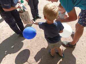 Zdjęcie przedstawiające policjantów w trakcie wręczania balonu.