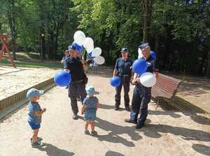 Zdjęcie przedstawiające policjantów w trakcie wręczania baloników.