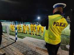 Zdjęcie przedstawiające policjanta oraz piłkarzy.