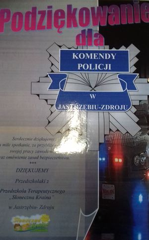 Zdjęcie kolorowe przedstawiające podziękowanie od przedszkolaków na którym widoczna jest odznaka policyjna.