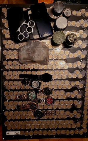 Zdjęcie przedstawiające zabezpieczone pieniądze, zegarki oraz inne przedmioty.