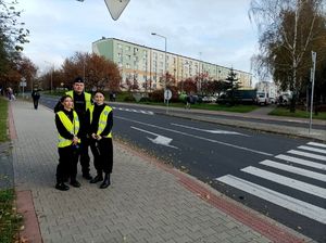 Zdjęcie kolorowe przedstawiające uczniów klas mundurowych oraz policjanta prewencji.