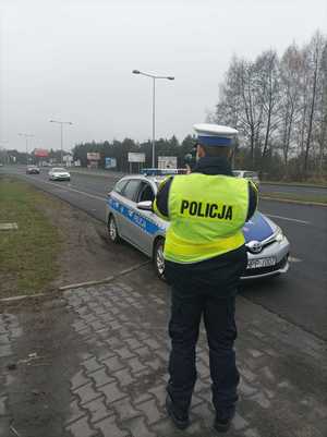 Zdjęcie policjanta ruchu drogowego dokonującego pomiaru prędkości.