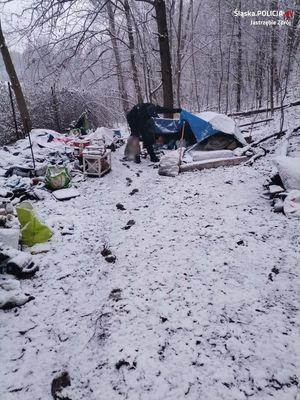 Zdjęcie przedstawiające policjanta, który kontroluje miejsce przebywania osoby bezdomnej.