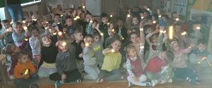 Zdjęcie przedstawiające policjantów oraz dzieci, które trzymają otrzymane opaski odblaskowe.